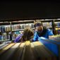 Beatrix Robb, 13, of Brattleboro, Vt., and her mother, Jen, look for a book at the Brooks Memorial Library, in Brattleboro, Vt., Friday, Nov. 13, 2020. The library plans to close its doors on Thanksgiving and reopen on Dec. 14, 2020, as the number of COVID-19 cases are on the rise in the area. (Kristopher Radder/The Brattleboro Reformer via AP)