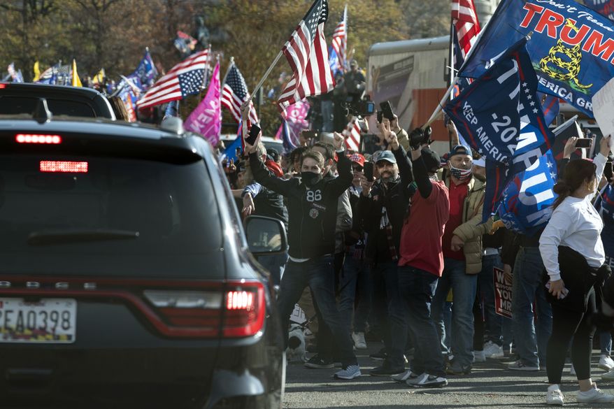 President Donald Trump drives by a group of supporters participating in a rally near the White House, Saturday, Nov. 14, 2020, in Washington. (AP Photo/Evan Vucci)
