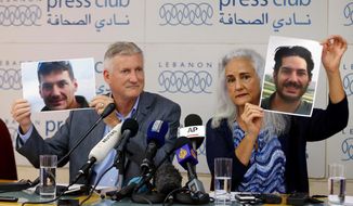 FILE - In this July 20, 2017, file photo, Marc and Debra Tice, the parents of Austin Tice, who has been missing in Syria since August 2012, hold up photos of him during a new conference, at the Press Club, in Beirut, Lebanon.   A top Lebanese security official, Maj. Gen. Abbas Ibrahim said Saturday, Nov. 14, 2020,  that after returning from Washington recently he visited Syria for two days where he spoke with officials about American journalist Austin Tice who has been missing in the war-torn country since 2012.   (AP Photo/Bilal Hussein, File)