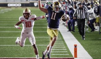 Notre Dame wide receiver Ben Skowronek (11) runs the ball in for a touchdown against Boston College defensive back Brandon Sebastian (10) during the first half of an NCAA college football game, Saturday, Nov. 14, 2020, in Boston. (AP Photo/Michael Dwyer)