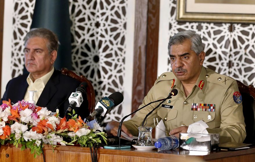 Pakistan&#39;s military spokesman Maj. Gen. Babar Iftikhar, right, briefs to media while Foreign Minister Shah Mahmood Qureshi listens during a joint press conference regarding on going tension between Pakistan and India, in Islamabad, Pakistan, Saturday, Nov. 14, 2020. Pakistani and Indian troops clashed in disputed Kashmir, causing casualties and wounding more than 30 others on both sides, officials said. The fighting came amid increasing tension between the South Asian neighbors. (AP Photo/Anjum Naveed)