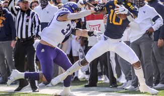 West Virginia wide receiver Sean Ryan (10) is pushed out of bounds by TCU linebacker Garret Wallow (30) during the first half of an NCAA college football game on Saturday, Nov. 14, 2020, in Morgantown, W.Va. (William Wotring/The Dominion-Post via AP)