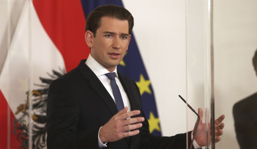 Austrian Chancellor Sebastian Kurz makes an address behind a plexiglass shield, at the federal chancellery in Vienna, Austria, Saturday, Nov. 14, 2020. The Austrian government has moved to restrict freedom of movement for people, in an effort to slow the onset of the COVID-19 coronavirus. (AP Photo/Ronald Zak)