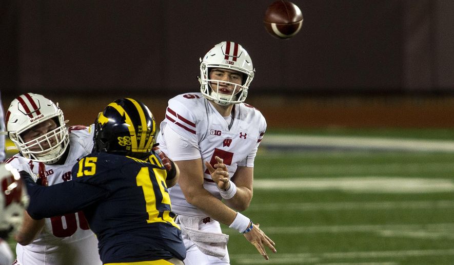 Wisconsin quarterback Graham Mertz (5) throws a pass in the first quarter of an NCAA college football game against Michigan in Ann Arbor, Mich., Saturday, Nov. 14, 2020. (AP Photo/Tony Ding)
