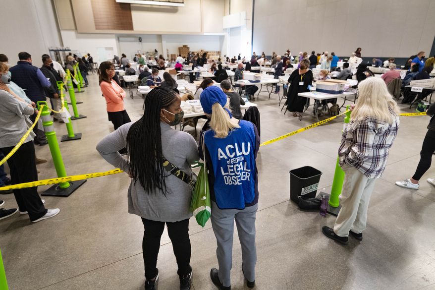 Democrat observers confer as they look on during a Cobb County hand recount of Presidential votes on Sunday, Nov. 15, 2020, in Marietta, Ga. (John Amis/Atlanta Journal &amp; Constitution via AP)