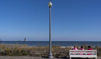 People enjoy a view of the beach, Friday, Nov. 13, 2020, in Rehoboth Beach, Del. This resort town known for Atlantic waves that are sometimes surfable, fresh-cut French fries and a 1-mile wooden boardwalk that dates back to the 1870s has long prided itself on being the “Nation&#39;s Summer Capital.” It may soon sport a beach White House. (AP Photo/Alex Brandon)