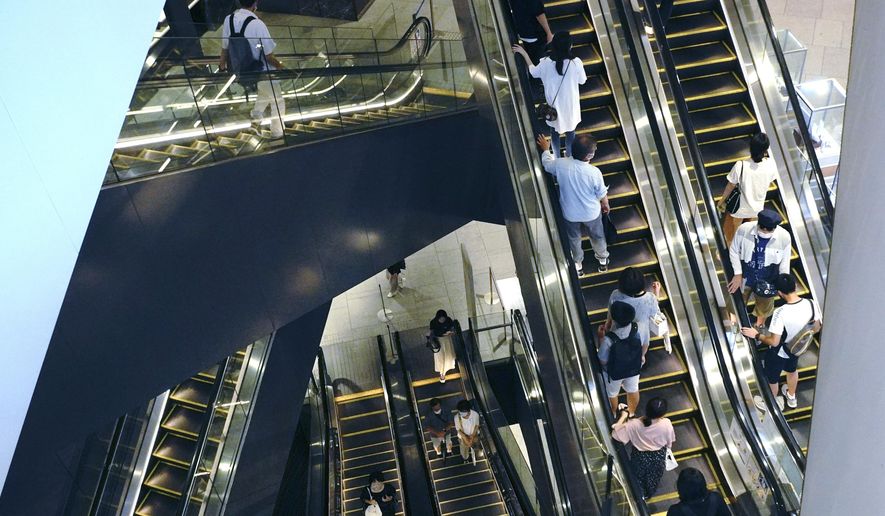 People take elevators at a shopping building in Tokyo Monday, Aug. 24, 2020. Japan&#39;s economy grew at an annual rate of 21.4% in the last quarter in a recovery from the shocks of the pandemic driven by both private spending and exports. (AP Photo/Eugene Hoshiko)