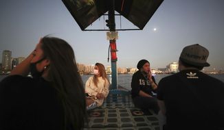 From left to right, April Joy, vocalist, Catherine Gallano, dancer and lead choreographer and Eric Roman, vocalist, cross the creek on a boat in Dubai, United Arab Emirates, Wednesday, Oct. 28, 2020.  As the coronavirus pandemic mutes Dubai&#39;s live-music scene, the Filipino show bands that long have animated the city&#39;s storied nightlife are being disproportionately squeezed. Many are out of work and out of money, struggling to survive in overcrowded dormitories at the mercy of employers (AP Photo/Kamran Jebreili)