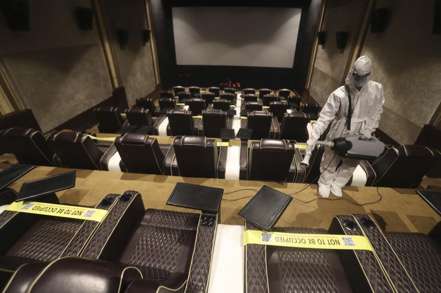 An employee sanitizes a cinema in Mumbai, India, Sunday, Nov. 15, 2020. India is second in the world in total reported coronavirus cases behind the U.S., but daily infections have been on the decline since the middle of September. (AP Photo/Rafiq Maqbool)