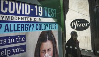A bus stop ad for COVID-19 testing is shown outside Pfizer world headquarters in New York on Monday Nov. 9, 2020. Pfizer says an early peek at its vaccine data suggests the shots may be 90% effective at preventing COVID-19, but it doesn&#39;t mean a vaccine is imminent. (AP Photo/Bebeto Matthews)