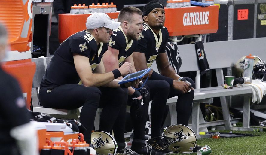 New Orleans Saints quarterbacks Drew Brees (9), Taysom Hill (7) and Jameis Winston (2), sit together on the bench in the second half of an NFL football game against the San Francisco 49ers in New Orleans, Sunday, Nov. 15, 2020. (AP Photo/Butch Dill)