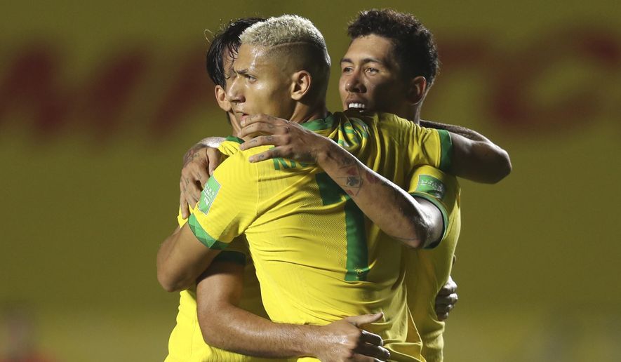 Brazil's Roberto Firmino, right, celebrates with teammates after scoring his side's opening goal against Venezuela during a qualifying soccer match for the FIFA World Cup Qatar 2022 in Sao Paulo, Brazil, Friday, Nov.13, 2020. (Fernando Bizerra/Pool via AP)