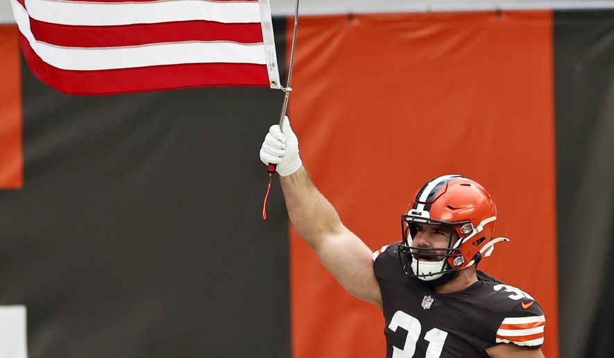 FILE - In this Nov. 15, 2020, file photo, Cleveland Browns running back Andy Janovich holds up a United States flag before an NFL football game against the Houston Texans in Cleveland. Janovich was placed on the COVID-list on Monday, Nov. 16, 2020, a day after he played in a win over the Texans. (AP Photo/Ron Schwane, File)