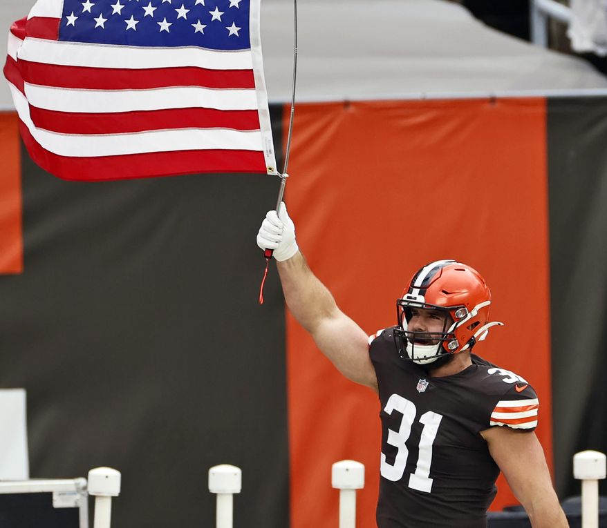 FILE - In this Nov. 15, 2020, file photo, Cleveland Browns running back Andy Janovich holds up a United States flag before an NFL football game against the Houston Texans in Cleveland. Janovich was placed on the COVID-list on Monday, Nov. 16, 2020, a day after he played in a win over the Texans. (AP Photo/Ron Schwane, File)