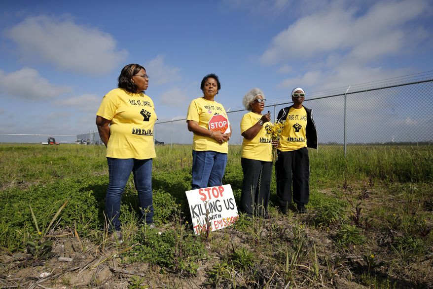 FILE - In this March 11, 2020, file photo, Myrtle Felton, from left, Sharon Lavigne, Gail LeBoeuf and Rita Cooper, members of RISE St. James, conduct a live stream video on property owned by Formosa in St. James Parish, La. The Army Corps of Engineers has suspended its permit for the Chinese conglomerate’s $9.4 billion plastics complex on a technicality, but says it may review other aspects of the permit. The Corps says it incorrectly dismissed sites in Ascension Parish when it reviewed whether other potential sites might have fewer environmental effects than the company's chosen location in St. James Parish. (AP Photo/Gerald Herbert, File)