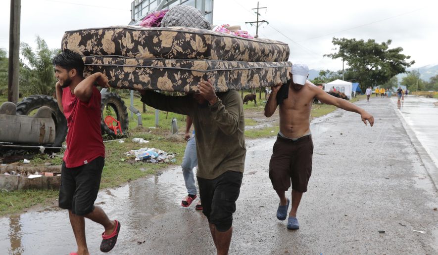 Neighbors help each other as they evacuate the area before Hurricane Iota makes landfall in San Manuel Cortes, Honduras, Monday, November 16, 2020. Hurricane Iota rapidly strengthened into a Category 5 storm that is likely to bring catastrophic damage to the same part of Central America already battered by a powerful Hurricane Eta less than two weeks ago. (AP Photo/Delmer Martinez)