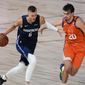 Dallas Mavericks forward Kristaps Porzingis (6) drives against Phoenix Suns forward Dario Saric (20) during the first half of an NBA basketball game Sunday, Aug. 2, 2020, in Lake Buena Vista, Fla. Porzingis will miss the start of the season as the Mavericks star continues recovery from surgery to repair a torn meniscus in his right knee. Director of basketball operations Donnie Nelson said in a radio interview Monday, Nov. 16, 2020, the club was being cautious with Luka Doncic&#39;s European sidekick, who missed more than a season because of another knee injury.(AP Photo/Ashley Landis, Pool)