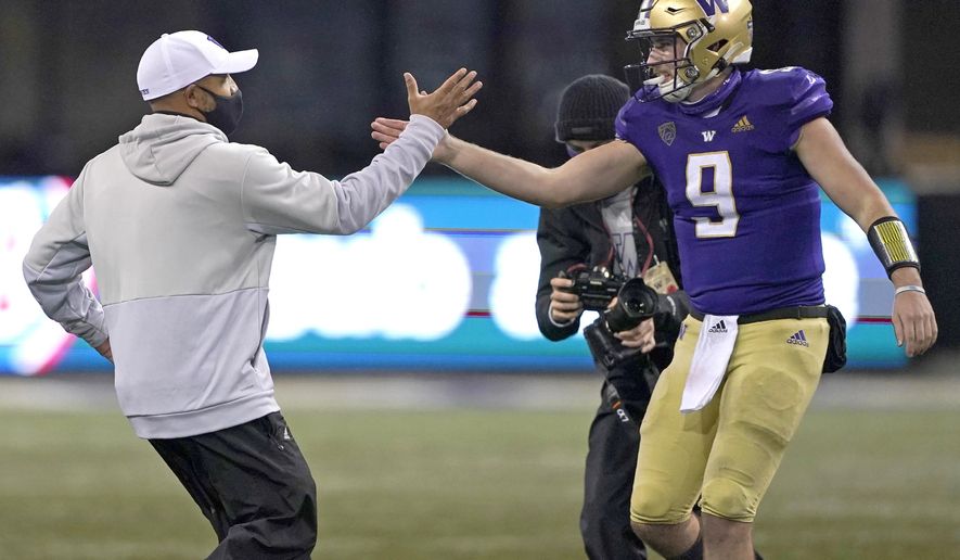Washington head coach Jimmy Lake, left, greets starting quarterback Dylan Morris (9) after Washington beat Oregon State 27-21 in an NCAA college football game, Saturday, Nov. 14, 2020, in Seattle. The game was Lake's first since he was named head coach. (AP Photo/Ted S. Warren)