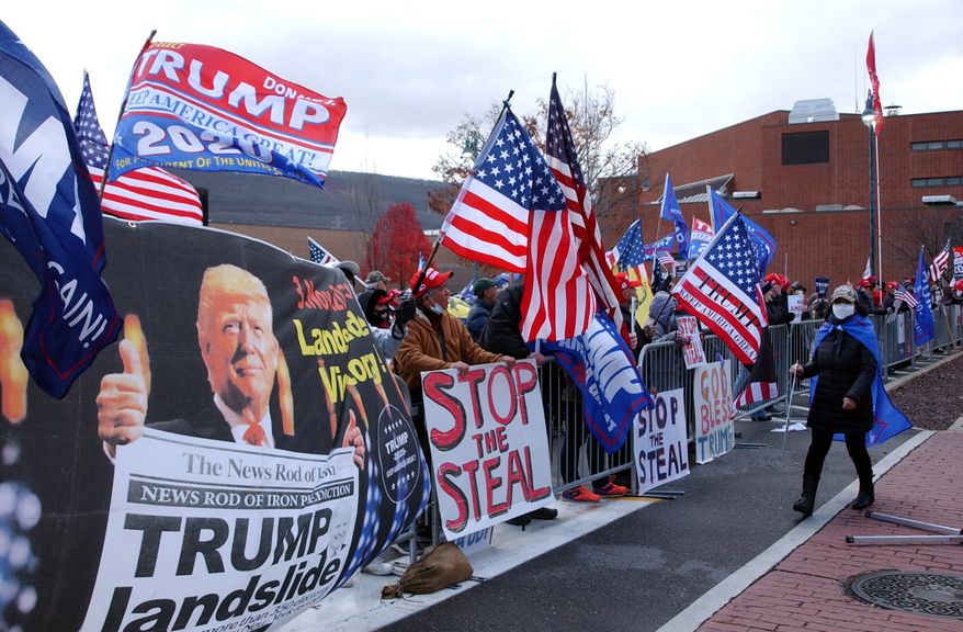 Approximately 100 Trump supporters some with flags and signs stood across West Third Street from the Federal Building in Williamsport, Pa., for hours Tuesday, Nov. 17, 2020, chanting such things as Four More Years, Black Lives Matter, We Want Trump and Dead People Cant Vote. Attorneys for the Trump campaign organization inside the Federal Building were arguing why the state and seven county election boards were arguing should not certify the results of the general election because voters across the state were not treated the same. (John Beauge/The Patriot-News via AP)