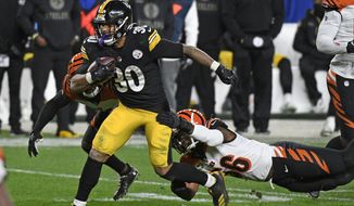 Pittsburgh Steelers running back James Conner (30) gets past Cincinnati Bengals middle linebacker Josh Bynes (56) during the second half of an NFL football game in Pittsburgh, Sunday, Nov. 15, 2020. (AP Photo/Don Wright)