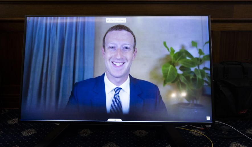 In this Oct. 28. 2020 file photo, Facebook CEO of Mark Zuckerberg appears on a screen as he speaks remotely during a hearing before the Senate Commerce Committee on Capitol Hill in Washington.  (Michael Reynolds/Pool via AP)  **FILE**