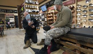 Patrick Marks, left, helps customer Jesus Chavez at Beck&#39;s Shoes in the Sutter County committee of Yuba City, Calif., Tuesday, Nov. 17, 2020. Gov. Gavin Newsom announced Monday that due to the rise of COVID-19 cases, Sutter was among the counties that has been moved to the state&#39;s most restrictive set of rules, which prohibit indoor dining and requiring people to wear face masks in public. The new rules began on Tuesday. (AP Photo/Rich Pedroncelli)
