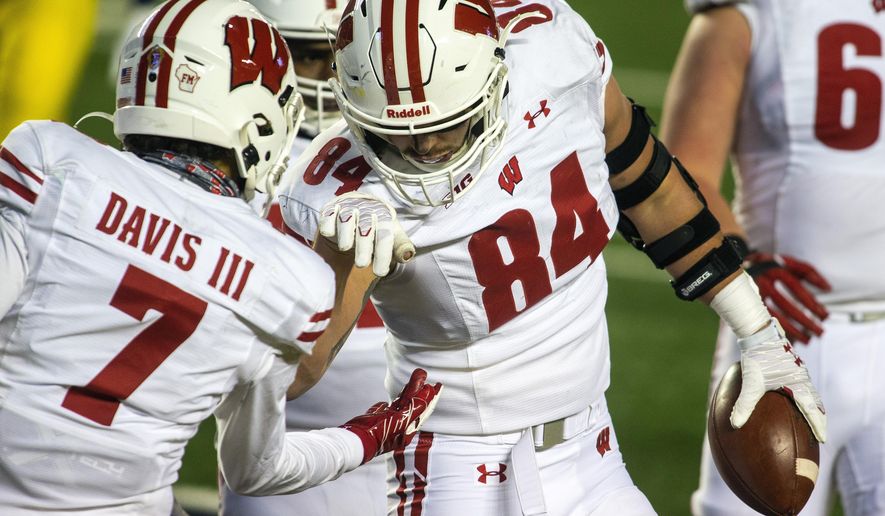 Wisconsin tight end Jake Ferguson (84) celebrates his touchdown with wide receiver Danny Davis III (7) in the third quarter of the team's NCAA college football game against Michigan in Ann Arbor, Mich., Saturday, Nov. 14, 2020. Wisconsin won 49-11. (AP Photo/Tony Ding)