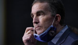 Virginia Gov. Ralph Northam removes his mask to answer a question during a COVID-19 briefing at the Capitol in Richmond, Va, Wednesday Nov 18, 2020. (AP Photo/Steve Helber)