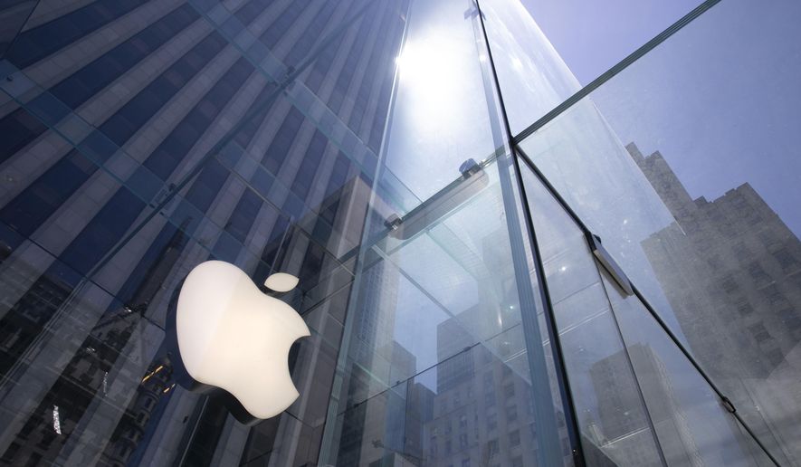 FILE - In this June 16, 2020, file photo, the sun is reflected on Apple&#39;s Fifth Avenue store in New York. Apple will cut its app store fee in half from 30% to 15% for most developers beginning Jan. 1, the biggest change in its commission rate since the app store began in 2008. The fee reduction will apply to developers who made up to $1 million from the app store in 2020, which is the “vast majority” of developers in the store, Apple said. (AP Photo/Mark Lennihan, File)