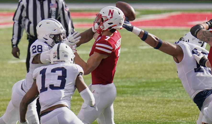 Nebraska quarterback Luke McCaffrey (7) throws an interception while under pressure from Penn State defensive end Jayson Oweh (28), defensive end Shaka Toney (18) and linebacker Ellis Brooks (13), during the second half of an NCAA college football game in Lincoln, Neb., Saturday, Nov. 14, 2020. Nebraska won 30-23. (AP Photo/Nati Harnik)