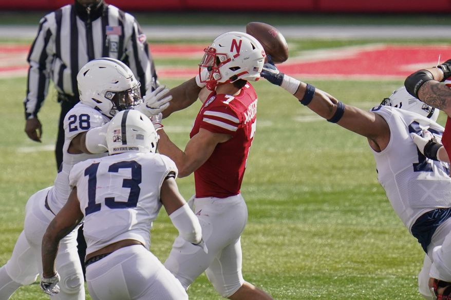 Nebraska quarterback Luke McCaffrey (7) throws an interception while under pressure from Penn State defensive end Jayson Oweh (28), defensive end Shaka Toney (18) and linebacker Ellis Brooks (13), during the second half of an NCAA college football game in Lincoln, Neb., Saturday, Nov. 14, 2020. Nebraska won 30-23. (AP Photo/Nati Harnik)