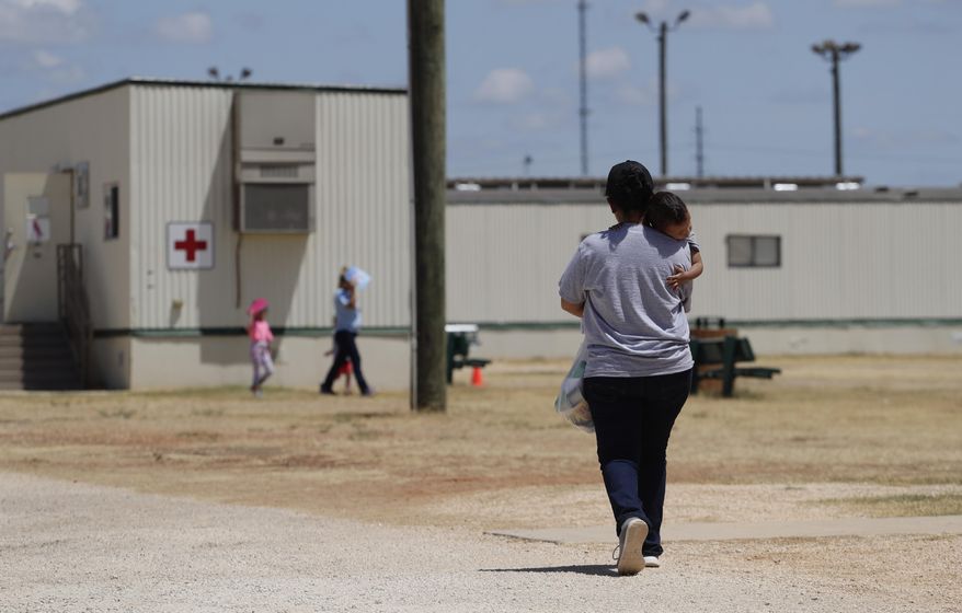 In this Aug. 23, 2019, photo, immigrants seeking asylum walk at the ICE South Texas Family Residential Center, in Dilley, Texas. A federal judge on Wednesday, Nov. 18, 2020, ordered the Trump administration to stop expelling immigrant children who cross the southern border alone, halting a policy that has resulted in thousands of rapid deportations of minors during the coronavirus pandemic. (AP Photo/Eric Gay) **FILE**