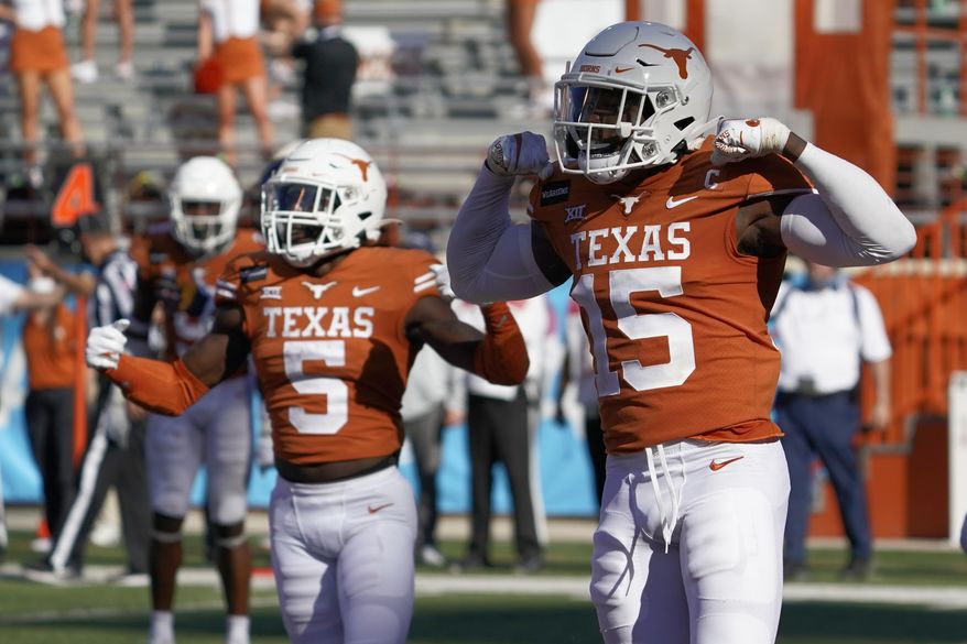 Texas' Chris Brown (15) and D'Shawn Jamison (5) celebrates after a stop against West Virginia on fourth down late during the second half of an NCAA college football game in Austin, Texas, Saturday, Nov. 7, 2020. (AP Photo/Chuck Burton)