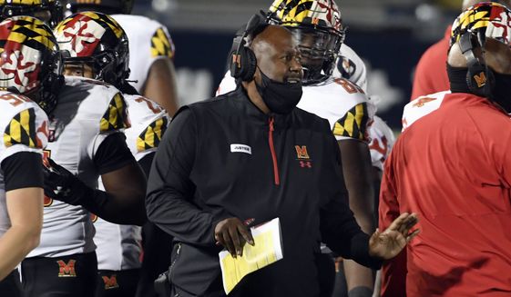 FILE - In this Saturday, Nov. 7, 2020, file photo, Maryland head coach Mike Locksley, center, talks with his players during a timeout late in the fourth quarter of an NCAA college football game against Penn State in State College, Pa. An outbreak of COVID-19 on the Maryland football team that resulted in a positive test for head coach Michael Locksley has caused the cancellation of Saturday’s Big Ten game against Michigan State. (AP Photo/Barry Reeger, File)