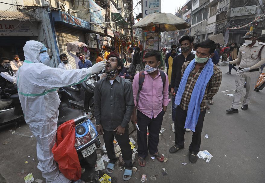A health worker takes a sample to test for COVID-19 test at a market place in New Delhi, India, Thursday, Nov. 19, 2020. India&#x27;s confirmed coronavirus caseload is expected to surpass 9 million on Friday as authorities in New Delhi battle to slow down the surge of infections in the city by increasing testing. The country&#x27;s overall tally of confirmed cases is currently the second largest in the world behind the United States. (AP Photo/Manish Swarup)