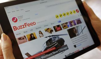 FILE- In this Sept. 2, 2015, file photo the BuzzFeed website is displayed on an iPad held by an Associated Press staffer in Los Angeles. BuzzFeed is buying HuffPost from Verizon as part of a bigger deal that has the wireless giant investing in the digital-media company. (AP Photo/Richard Vogel, File)