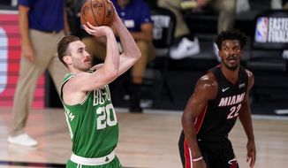 Boston Celtics forward Gordon Hayward (20) takes a shot as Miami Heat&#39;s Jimmy Butler (22) looks on during the second half of Game 4 of an NBA basketball Eastern Conference final, Wednesday, Sept. 23, 2020, in Lake Buena Vista, Fla. (AP Photo/Mark J. Terrill)