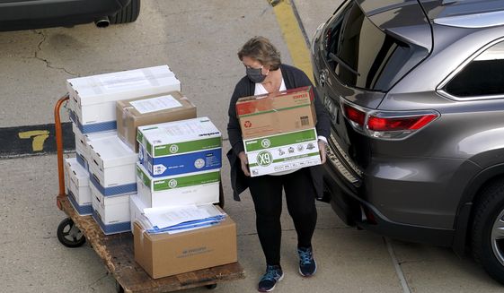 Election officials from around Dane County bring ballots in, Thursday, Nov., 19, 2020 to the Monona Terrace in Madison, Wis. for the recount that begins Friday. (Steve Apps/Wisconsin State Journal via AP)