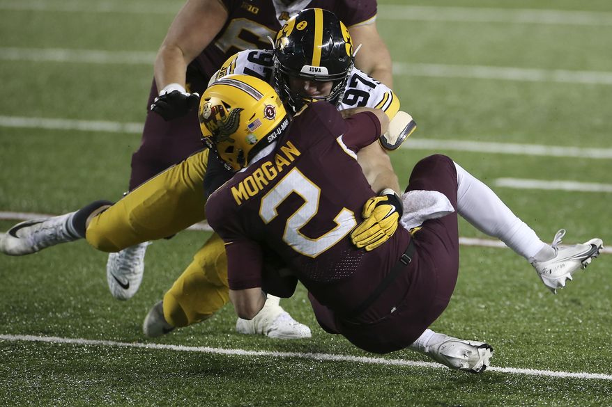 Iowa defensive lineman Zach VanValkenburg (97) sacks Minnesota quarterback Tanner Morgan (2) during the second half of an NCAA college football game Friday, Nov. 13, 2020, in Minneapolis. Iowa won 35-7. (AP Photo/Stacy Bengs)