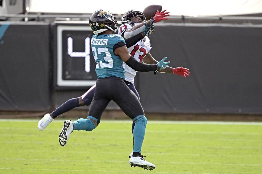 Jacksonville Jaguars cornerback CJ Henderson, left, breaks up a pass intended for Houston Texans wide receiver Brandin Cooks (13) during the first half of an NFL football game, Sunday, Nov. 8, 2020, in Jacksonville, Fla. (AP Photo/Phelan M. Ebenhack)