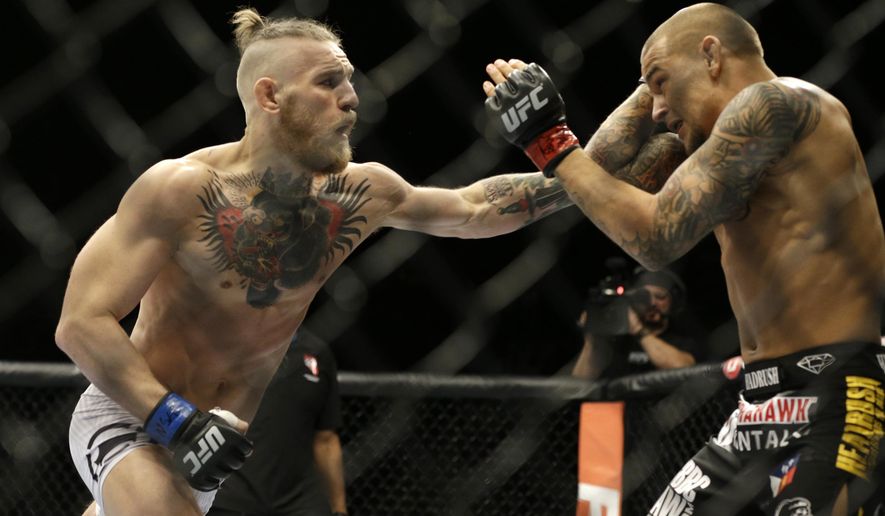FILE - In this Sept. 27, 2014, file photo, Conor McGregor, left, and Dustin Poirier, exchange hits during their mixed martial arts bout in Las Vegas. UFC President Dana White confirmed to The Associated Press on Thursday, Nov. 19,2020, that McGregor has officially signed an agreement for a probable 155-pound fight with Poirier, ending McGregor&#39;s latest retirement from mixed martial arts. (AP Photo/John Locher, File)