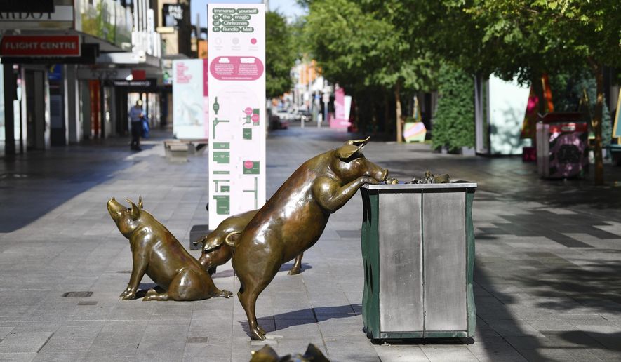 Sculptures of pigs are displayed in a nearly empty pedestrian mall in Adelaide, Australia, Thursday, Nov. 19, 2020. South Australia state that includes the city of Adelaide is in a six-day lockdown schools, universities, bars and cafes closed from Thursday and only one person from each household will be allowed to leave home each day, and only for specific reasons. (David Mariuz/AAP Image via AP)