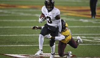 Purdue wide receiver David Bell (3) tries to get away from Minnesota defensive back Justus Harris (21) during the first half of an NCAA college football game Friday, Nov. 20, 2020, in Minneapolis. (AP Photo/Stacy Bengs)