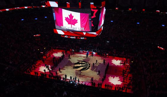 FILE - In this April 16, 2019, file photo, fans sing the Canadian national anthem before Game 2 of an NBA basketball first-round playoff series between the Orlando Magic and the Toronto Raptors in Toronto. The Canadian government has denied a request by the NBA and the Raptors to play in Toronto amid the pandemic. An official familiar with the federal government’s decision told The Associated Press on Friday, Nov. 20, 2020, there is too much COVID-19 circulating in the United States to allow for cross-border travel that is not essential. (Nathan Denette/The Canadian Press via AP, File)