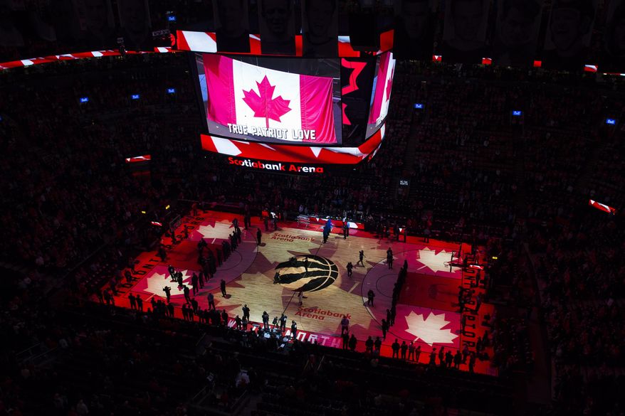 FILE - In this April 16, 2019, file photo, fans sing the Canadian national anthem before Game 2 of an NBA basketball first-round playoff series between the Orlando Magic and the Toronto Raptors in Toronto. The Canadian government has denied a request by the NBA and the Raptors to play in Toronto amid the pandemic. An official familiar with the federal government’s decision told The Associated Press on Friday, Nov. 20, 2020, there is too much COVID-19 circulating in the United States to allow for cross-border travel that is not essential. (Nathan Denette/The Canadian Press via AP, File)