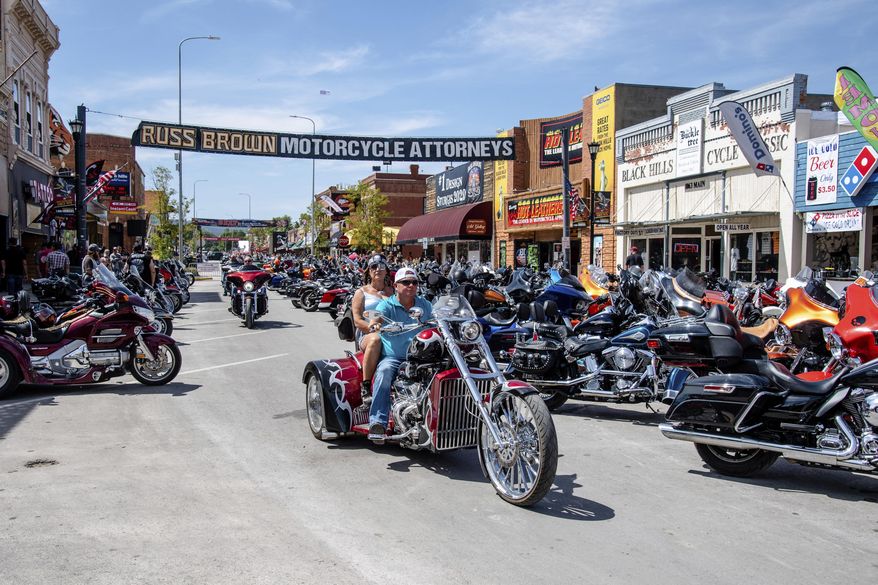 FILE - In this Aug. 15, 2020 file photo, bikers ride down Main Street during the 80th annual Sturgis Motorcycle Rally in Sturgis, S.D. This summer’s huge motorcycle rally in South Dakota led to dozens of coronavirus cases in neighboring Minnesota. That’s the finding of a report Friday, Nov. 20, from the Centers for Disease Control and Prevention. (Amy Harris/Invision/AP)