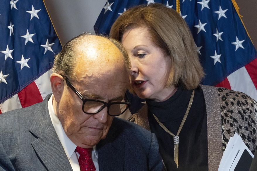 Former Mayor of New York Rudy Giuliani, left, President Trump&#x27;s personal lawyer, listens to Sidney Powell during a news conference at the Republican National Committee headquarters, Thursday, Nov. 19, 2020, in Washington. (AP Photo/Jacquelyn Martin)