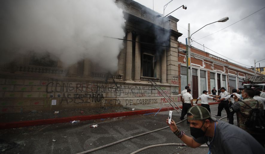 Clouds of smoke shoot out from the Congress building after protesters set it on fire, in Guatemala City, Saturday, Nov. 21, 2020. Hundreds of protesters were protesting in various parts of the country Saturday against Guatemalan President Alejandro Giammattei and members of Congress for the approval of the 2021 budget that reduced funds for education, health and the fight for human rights. (AP Photo/Moises Castillo)