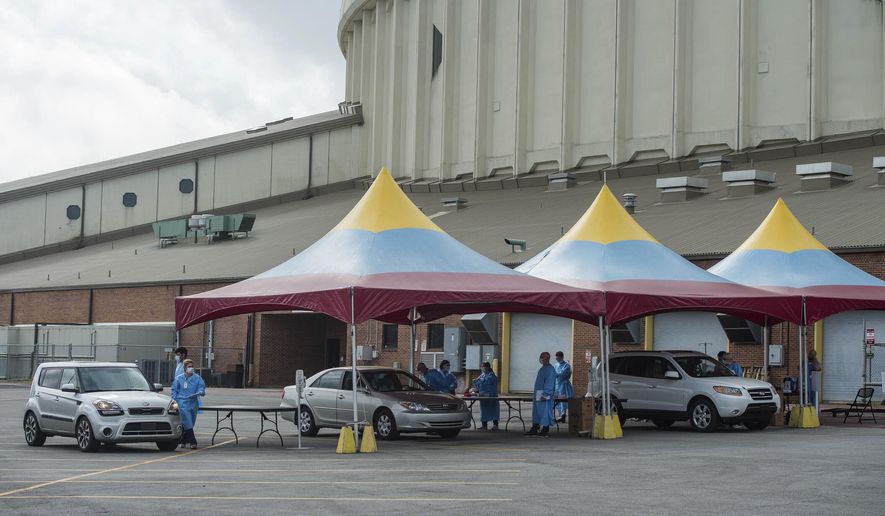 FILE - In this March 18, 2020 file photo, patients are evaluated at a drive-thru screening for the coronavirus at the Cajundome in Lafayette, La., Wednesday, March 18, 2020. This week could prove critical to bars across Lafayette Parish as the local COVID-19 positivity rate rocketed above the 5% threshold that allowed bars to reopen in September to 10.1% as of Nov. 18, up from 4.7% the week before. (Scott Clause/The Daily Advertiser via AP, File)