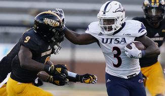 UTSA running back Sincere McCormick (3) fends off an attempted tackle by Southern Mississippi defensive back Malik Shorts (9) during the second half of an NCAA college football game, Saturday, Nov. 21, 2020, in Hattiesburg, Miss. UTSA won 23-20. (AP Photo/Rogelio V. Solis)